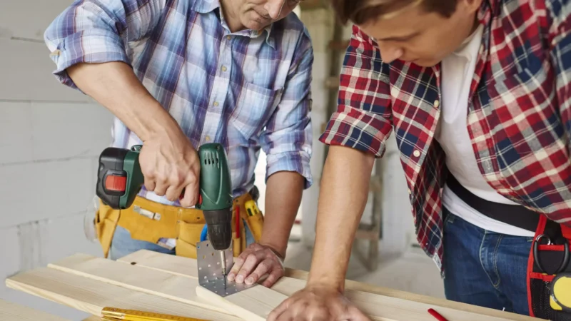 close-up-experienced-carpenter-his-younger-employee-min