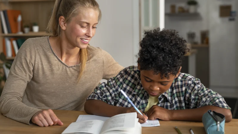 front-view-woman-helping-kid-with-homework